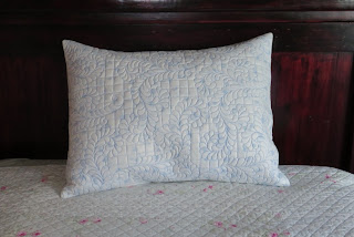 White quilted pillow on floral bedspread