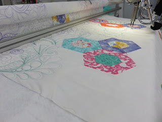 Longarm quilting machine stitching colorful hexagon quilt