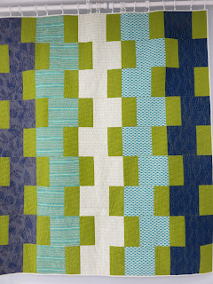 Geometric quilt with blue, green, white blocks