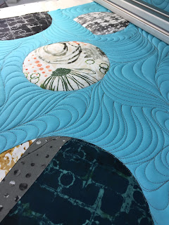 Turquoise quilt with circular fabric appliques