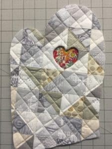 A quilt with a heart on it sitting on top of a table.