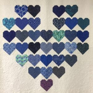 A heart made of blue hearts on top of a white wall.