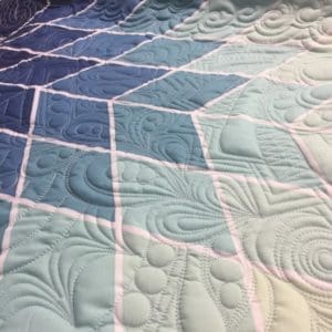 A close up of the quilt with blue and white designs