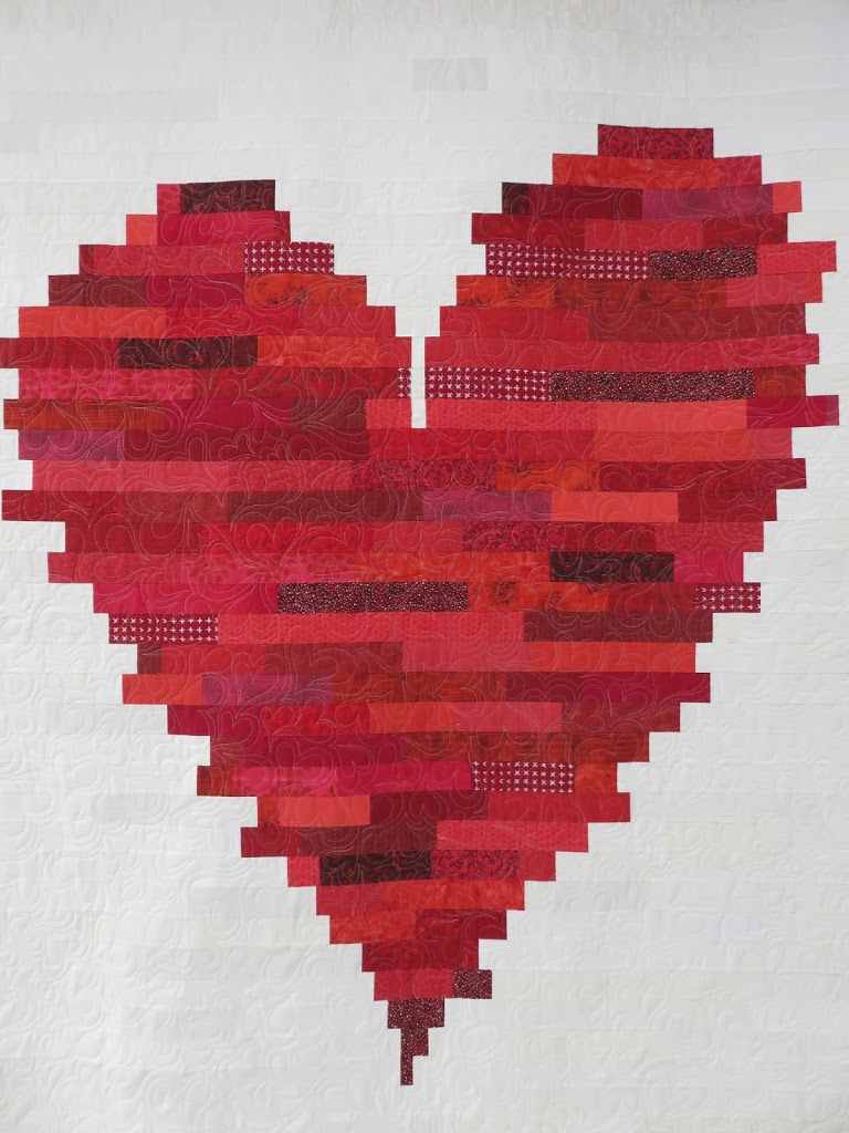 A red heart made of strips of fabric.