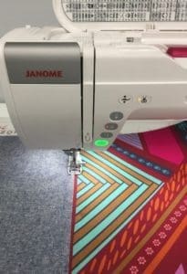 A sewing machine is shown with the needle in it.