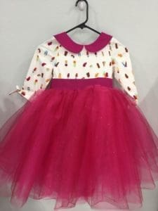 A pink dress with a collar and long sleeves.