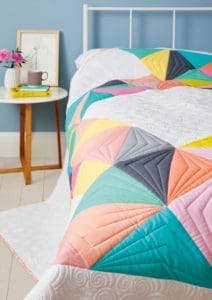 A bed with a colorful quilt on it