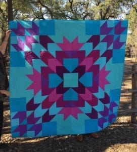 A quilt hanging up in the woods