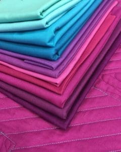 A stack of folded fabric in different colors.
