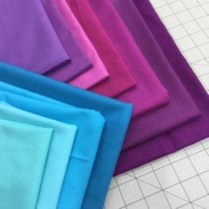 A close up of different colored fabrics on the floor