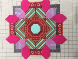A quilt with pink and red designs on it.
