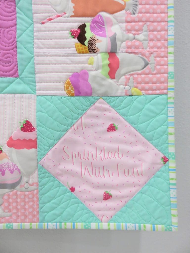 A close up of the quilt with cupcakes on it