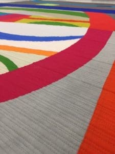 A close up of the colorful fabric on a quilt