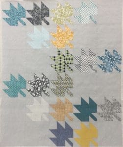 A quilt with leaves on it is shown.