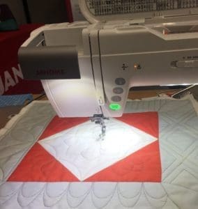 A sewing machine is shown with the quilting on it.