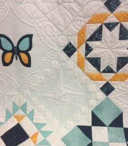 A close up of the quilt with a butterfly on it