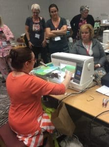 A woman is cutting paper with a machine.