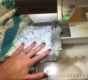 A person using a sewing machine to make fabric.
