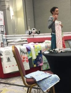A woman standing in front of a table with many different items.