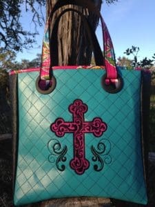 A cross on the front of a purse.