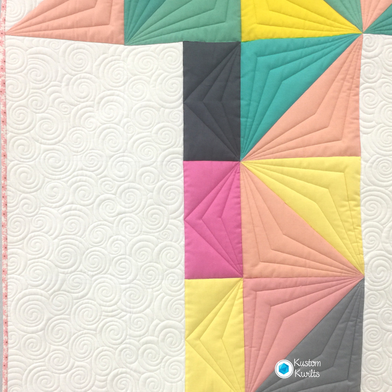 A quilt with colorful squares and triangles on it.