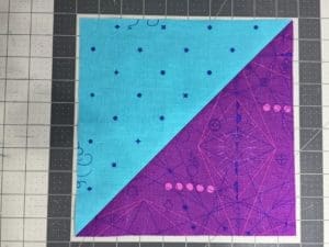 A purple and blue quilt on the floor