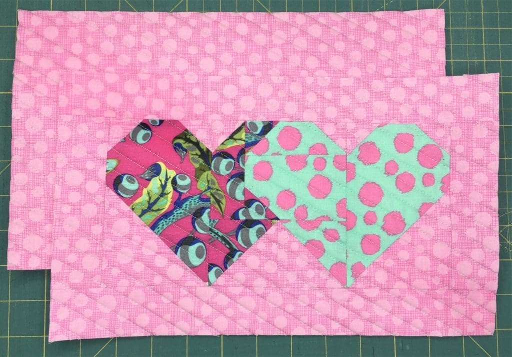 Two hearts are shown in a pattern of geometric shapes.