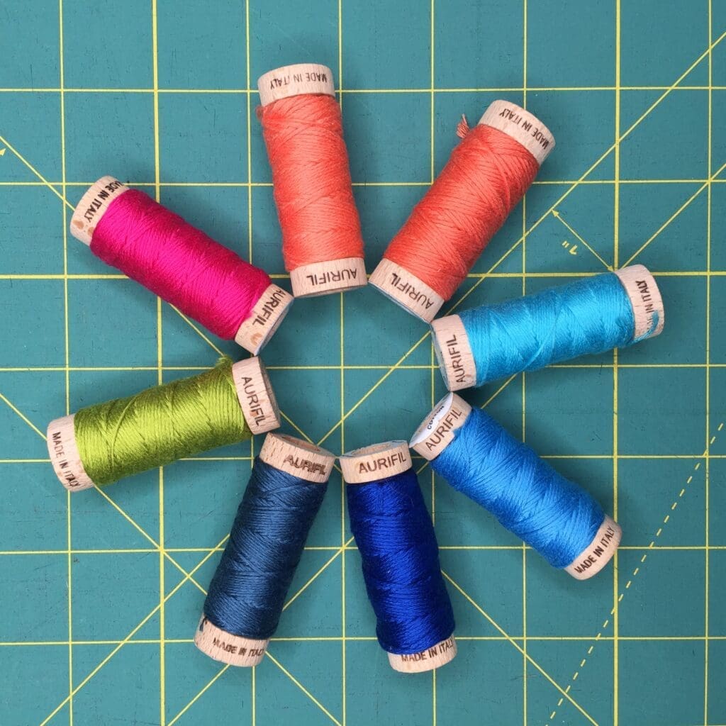 A circle of thread in different colors on a table.