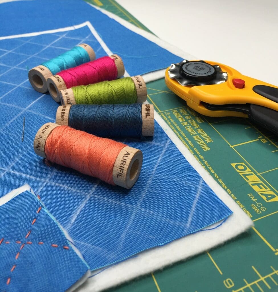 A pair of scissors and some thread on top of a table.
