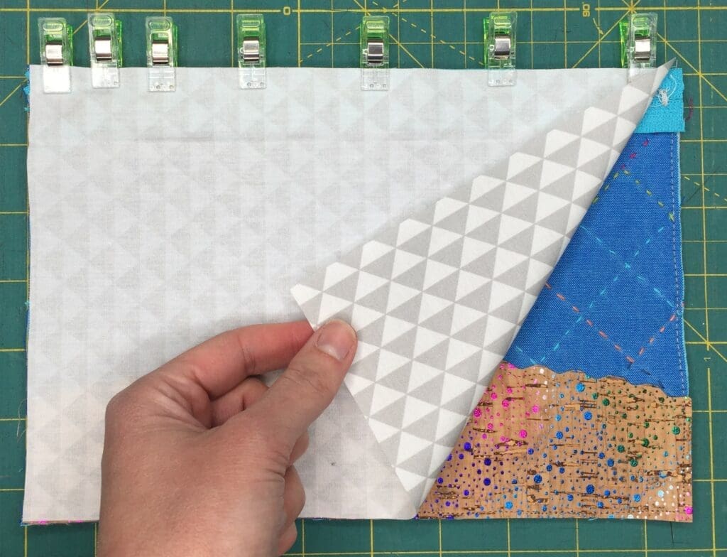 A person holding onto the corner of a quilt