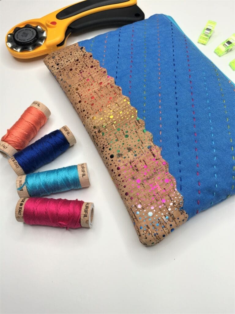 A blue bag with some thread and a spool of thread