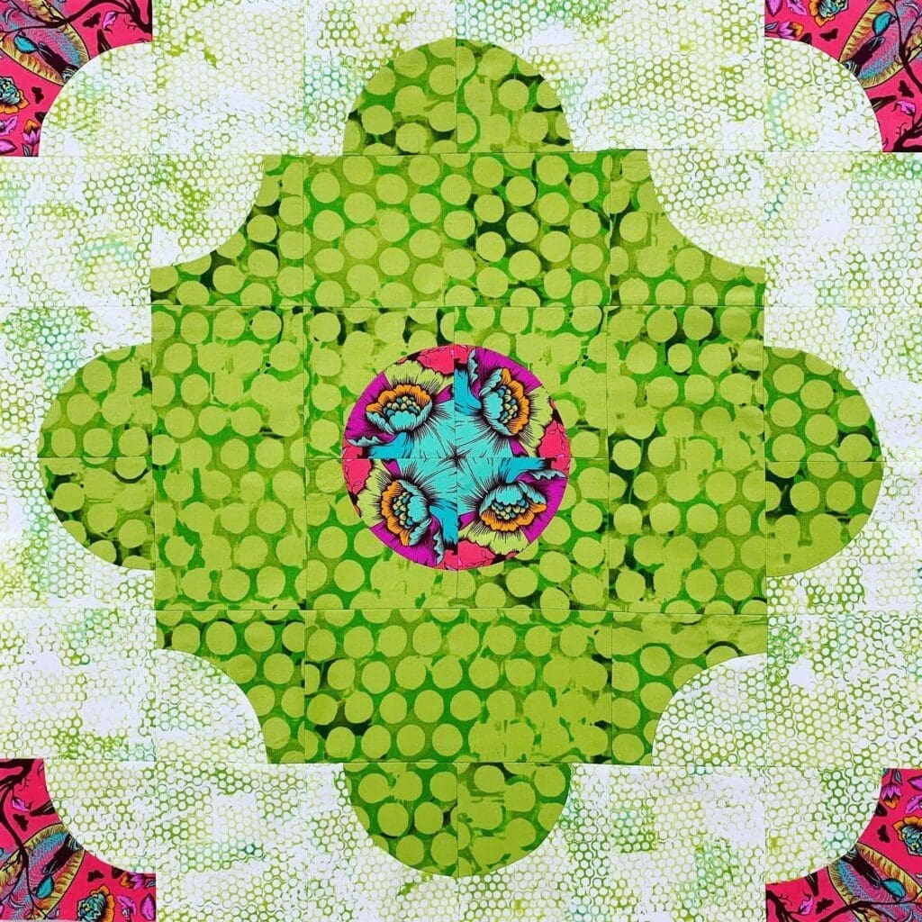 A green and pink flower with many circles