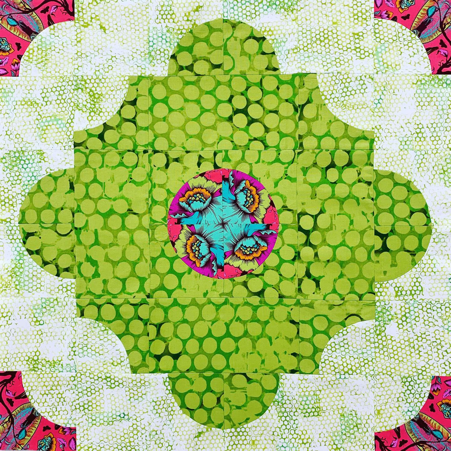 A green and pink flower with many circles