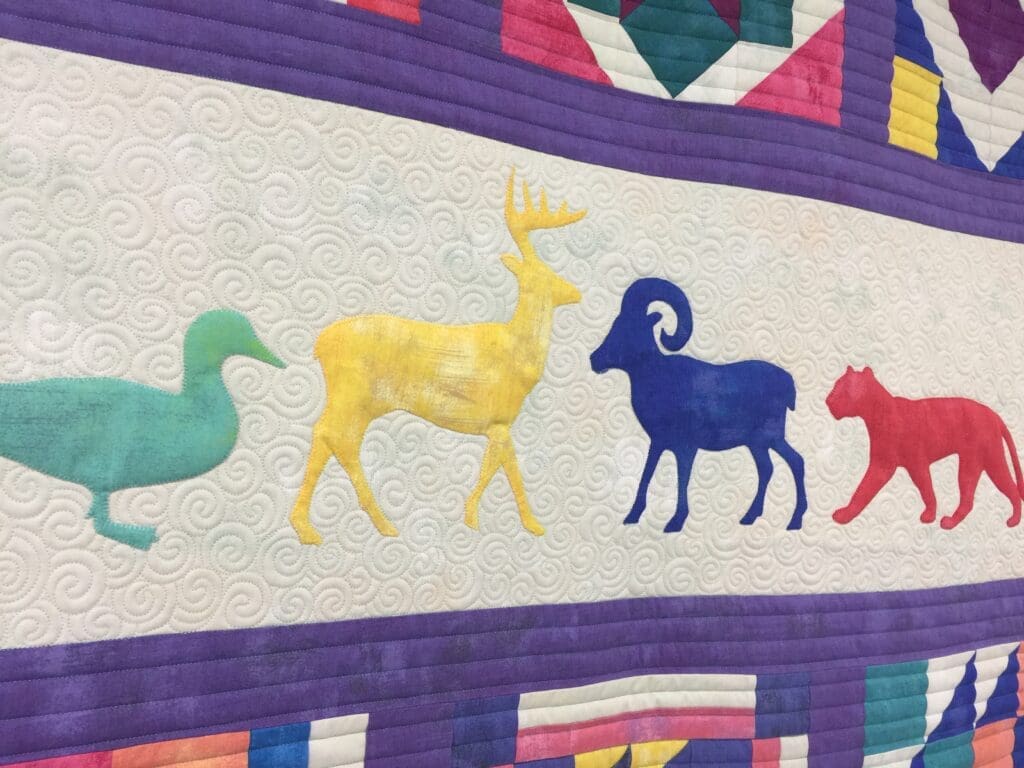 A colorful quilt with animals on it.