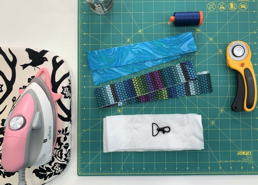 A green cutting mat with some fabric and scissors