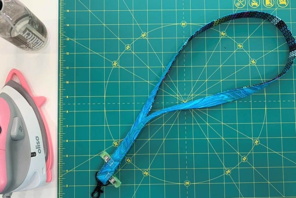 A green cutting mat with some fabric and scissors