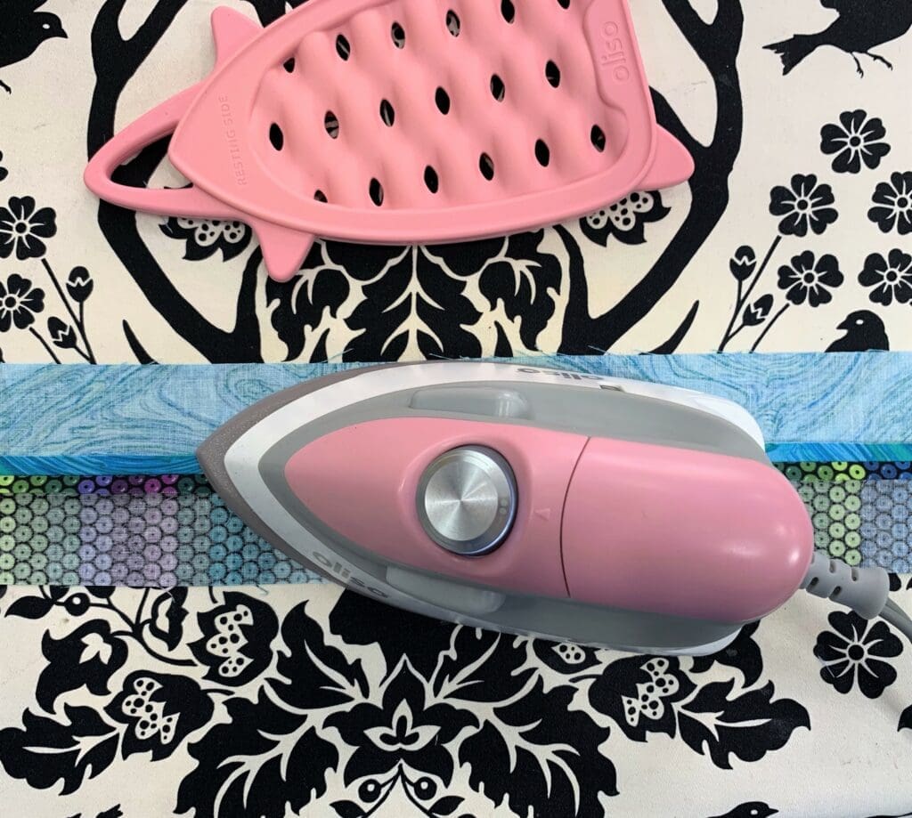 A pink iron and a black and white floral fabric