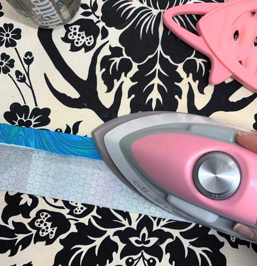 A pink iron and some black and white fabric