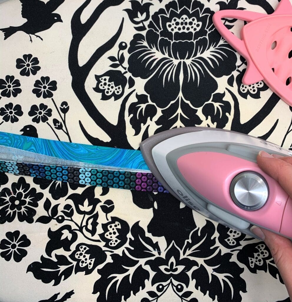 A person using an iron to cut fabric