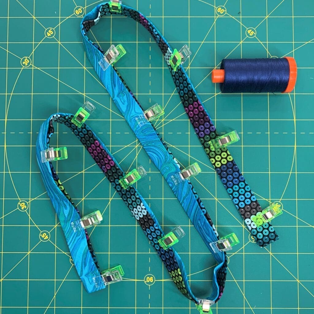 A blue and green lanyard laying on top of a table.