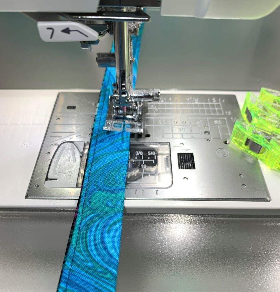 A sewing machine with a blue and green fabric on it.