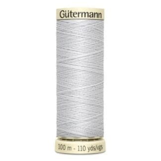 A spool of thread with white thread on it.