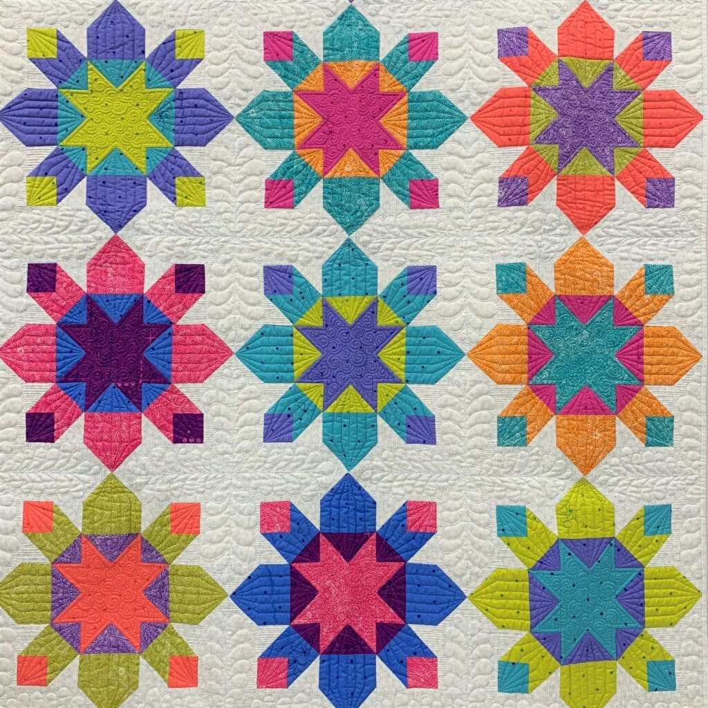 A quilt with different colored stars on it.
