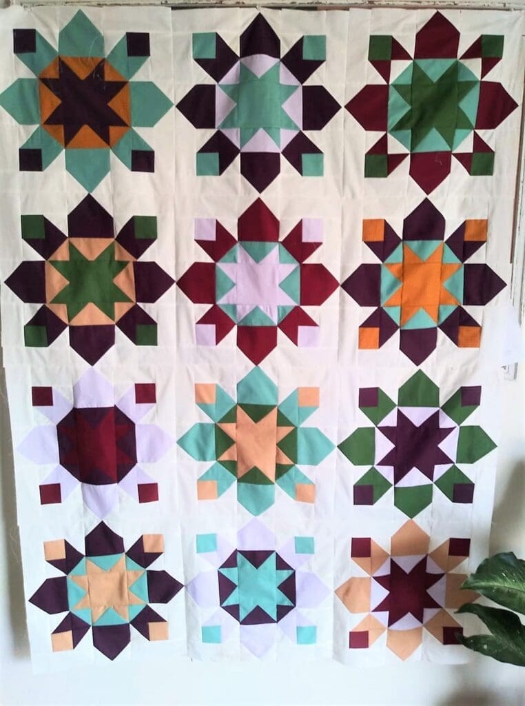 A quilt with different colored stars on it.