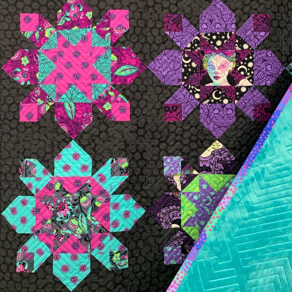 A quilt with different colored designs on it.