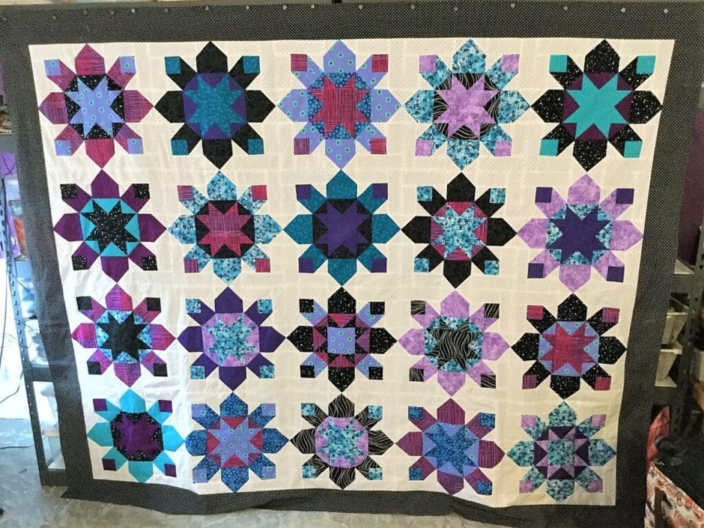 A quilt with different colored flowers on it.