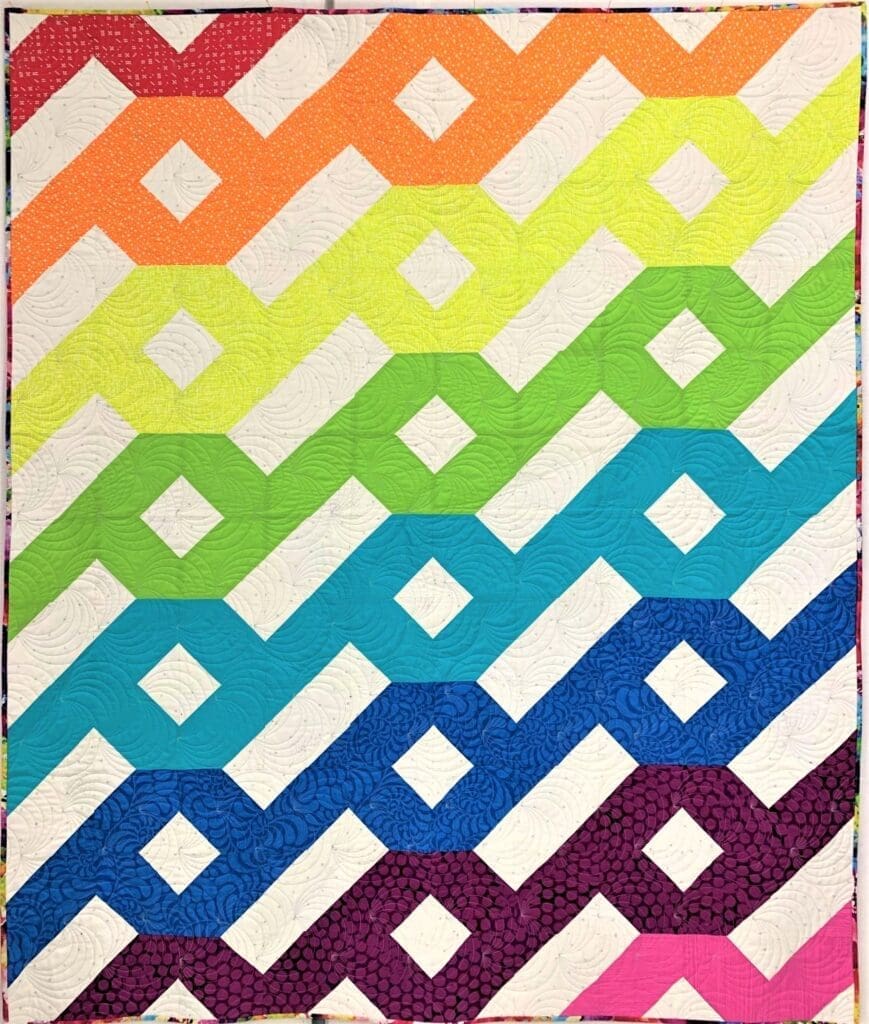 A colorful quilt with an abstract design.