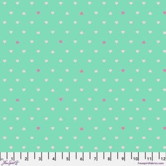 A green background with white and pink polka dots.