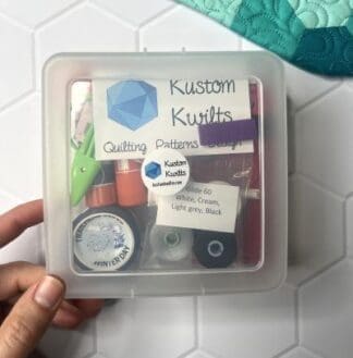A quilting starter kit with essential tools in a clear plastic case.