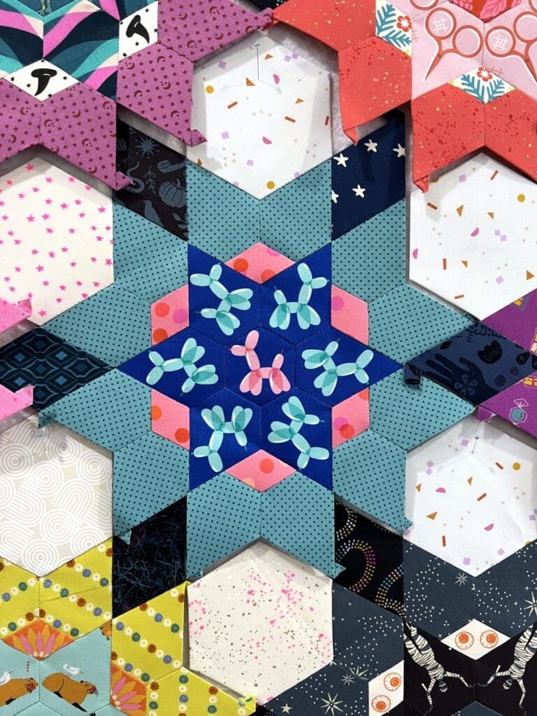Intricate star-shaped rangoli design with yellow and purple hues.